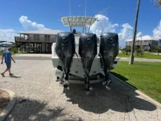 Slide: The Image of 2023 Contender 35 ST boat with four powerful outboard motors, parked outdoors. - 7