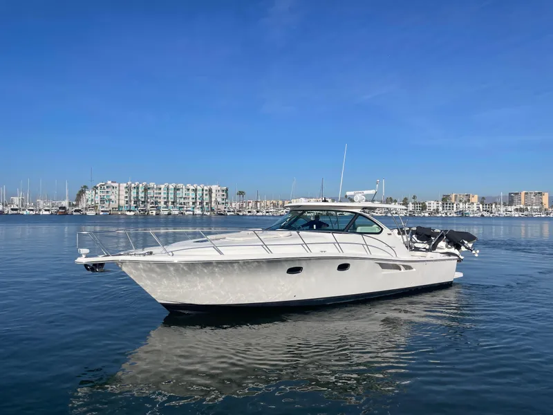 Slide: The Image of 2013 Tiara Yachts 3900 Open cruising in a marina under clear blue skies. - 3