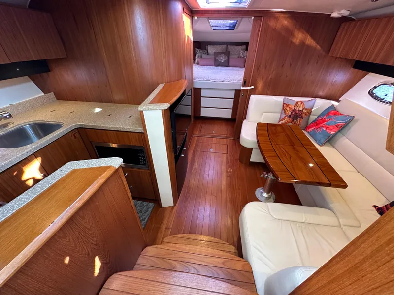 Slide: The Image of Interior of 2013 Tiara Yachts 3900 Open with wood finish and cozy seating area. - 32
