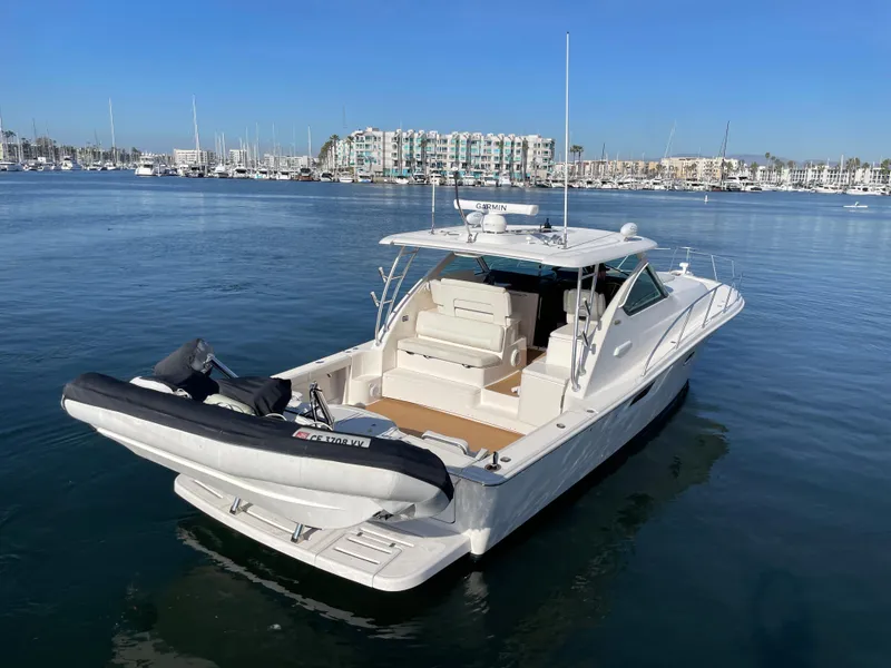 Slide: The Image of 2013 Tiara Yachts 3900 Open in marina, featuring spacious deck and inflatable boat. - 4