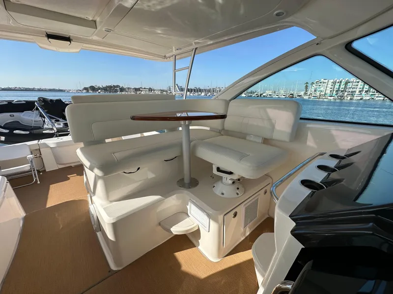 Slide: The Image of 2013 Tiara Yachts 3900 Open interior with seating and table, overlooking marina. - 46