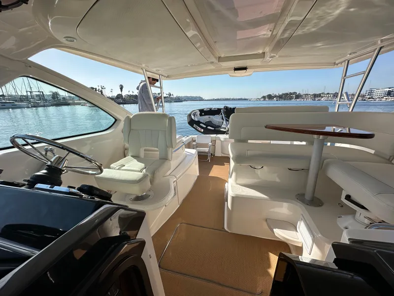 Slide: The Image of 2013 Tiara Yachts 3900 Open interior with seating and steering, docked by the water. - 47