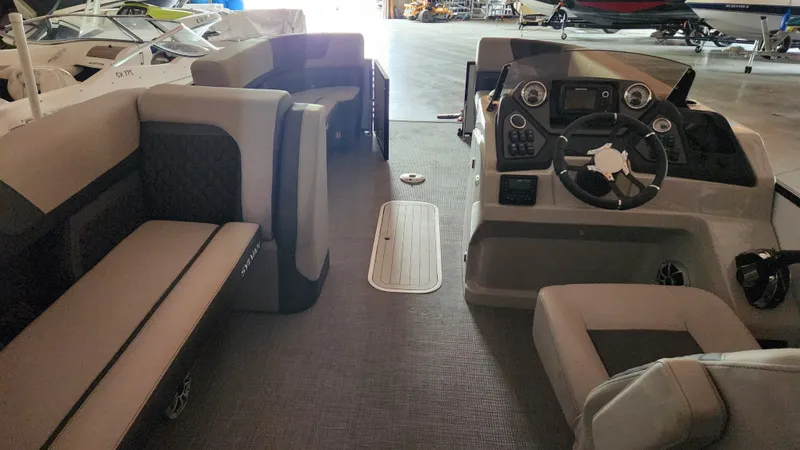 Slide: The Image of Interior of a 2026 Sylvan L3 pontoon boat with gray upholstery and a modern helm. - 28