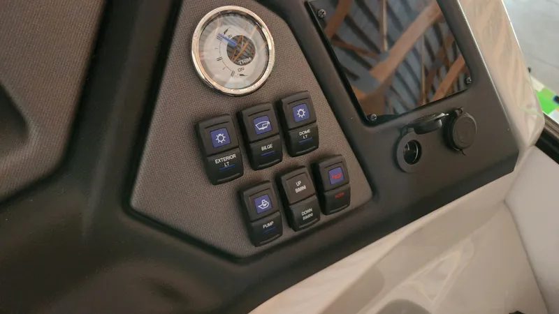 Slide: The Image of Close-up of a Sylvan L3 boat's helm with various switches and a gauge. - 23