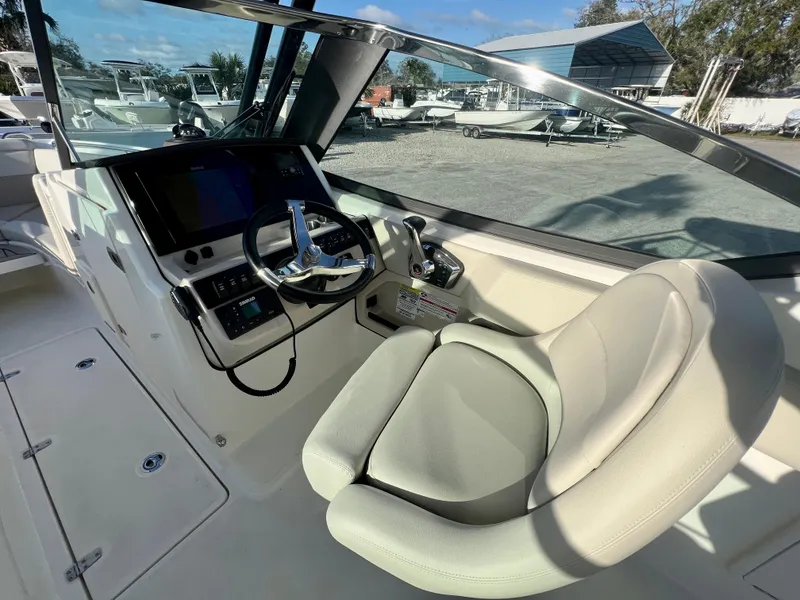 Slide: The Image of 2025 Boston Whaler 240 Vantage boat cockpit with steering wheel and comfortable seating. - 12
