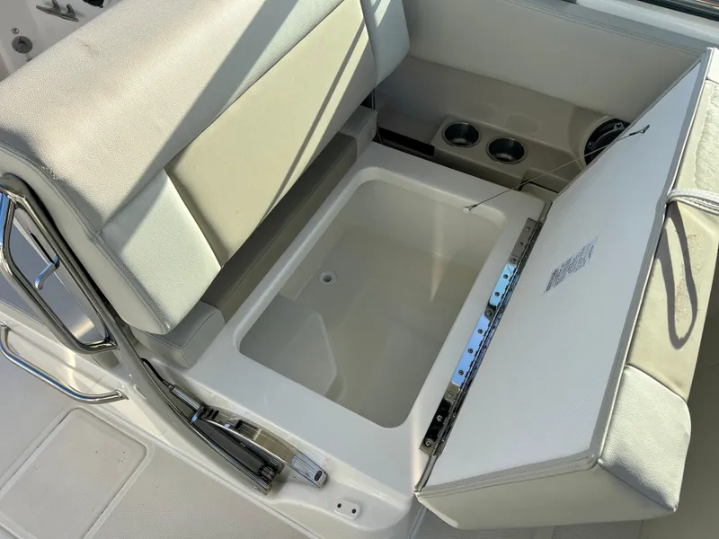 Slide: The Image of 2025 Boston Whaler 240 Vantage boat seat storage compartment with cup holders. - 20