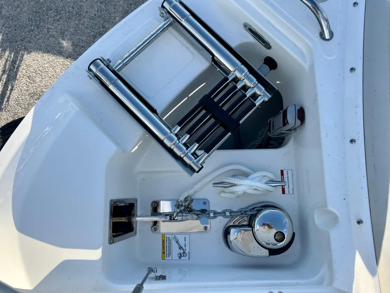 Slide: The Image of 2025 Boston Whaler 240 Vantage anchor compartment with ladder and chain. - 25
