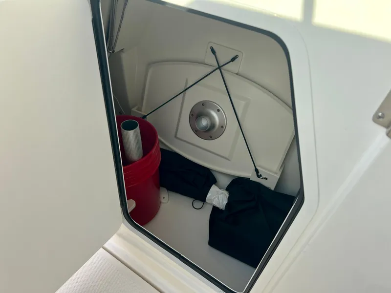 Slide: The Image of Storage compartment on a 2025 Boston Whaler 240 Vantage boat with cleaning supplies. - 26
