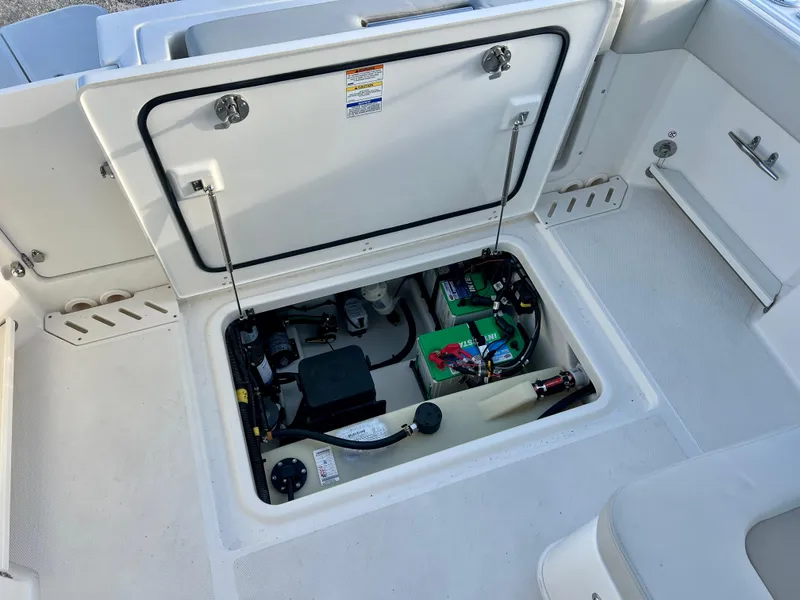 Slide: The Image of 2025 Boston Whaler 240 Vantage boat storage compartment with open hatch, revealing internal components. - 29
