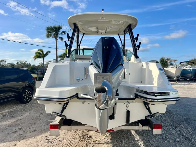 Slide: The Image of 2025 Boston Whaler 240 Vantage boat, rear view with outboard motor, parked outdoors. - 6
