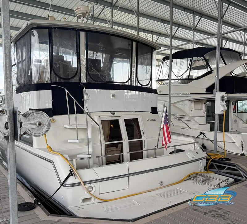 The Image of 1995 Carver 430 Cockpit Motor Yacht docked in a covered marina. - 0