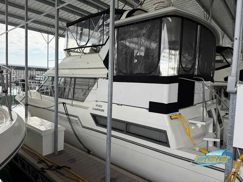 Slide: The Image of 1995 Carver 430 Cockpit Motor Yacht docked in a covered marina. - 1