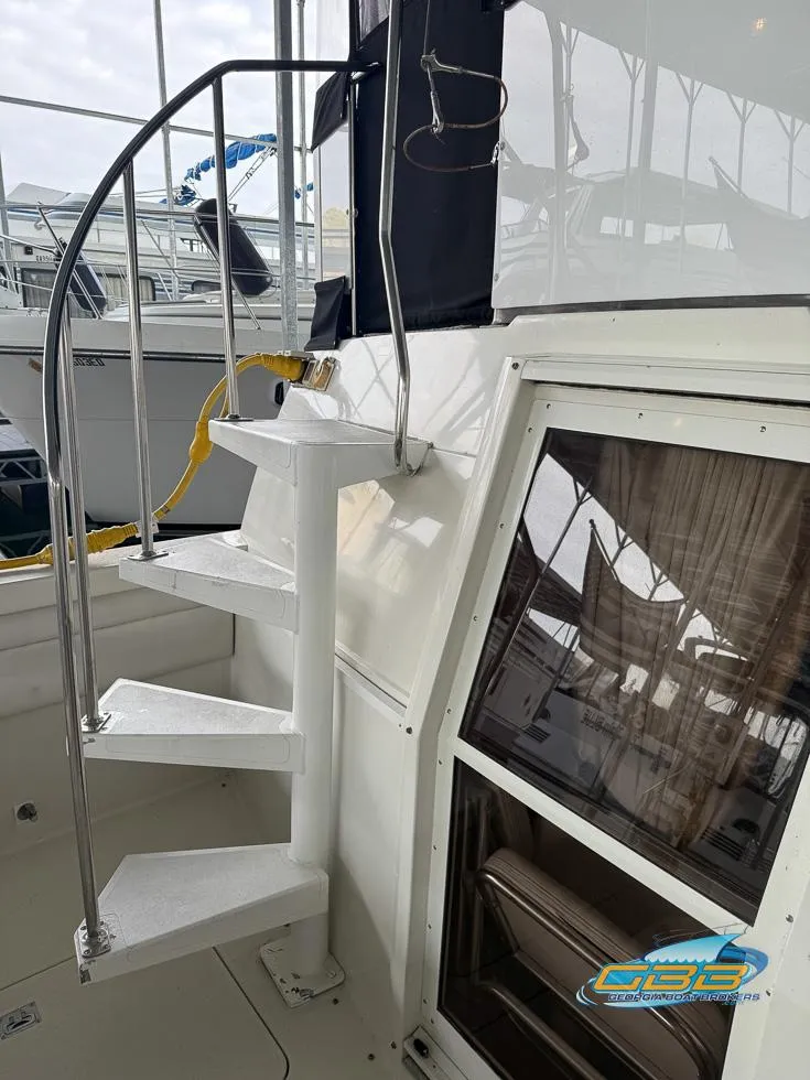 Slide: The Image of 1995 Carver 430 Cockpit Motor Yacht with spiral staircase and window detail. - 12