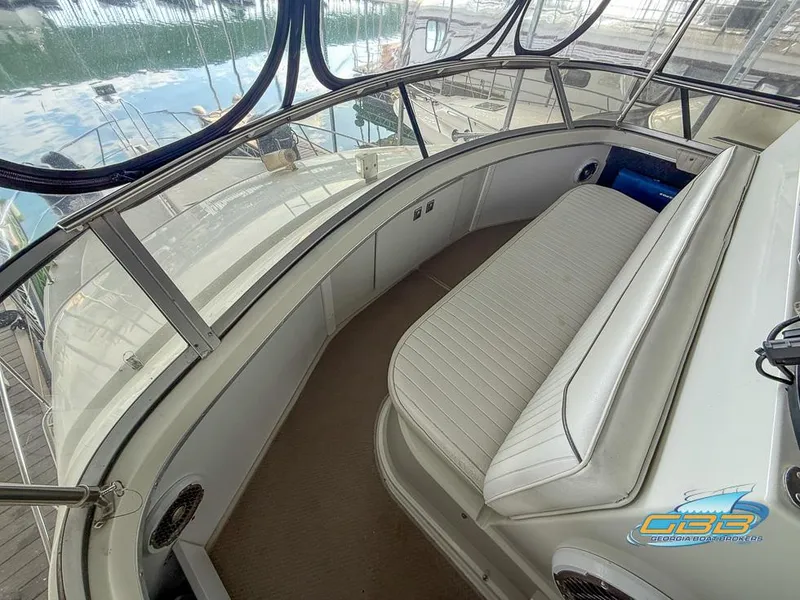 Slide: The Image of 1995 Carver 430 Cockpit Motor Yacht interior with cushioned seating and panoramic windows. - 15
