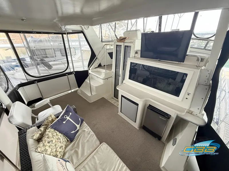 Slide: The Image of 1995 Carver 430 Cockpit Motor Yacht interior with seating, TV, and mini fridge. - 17