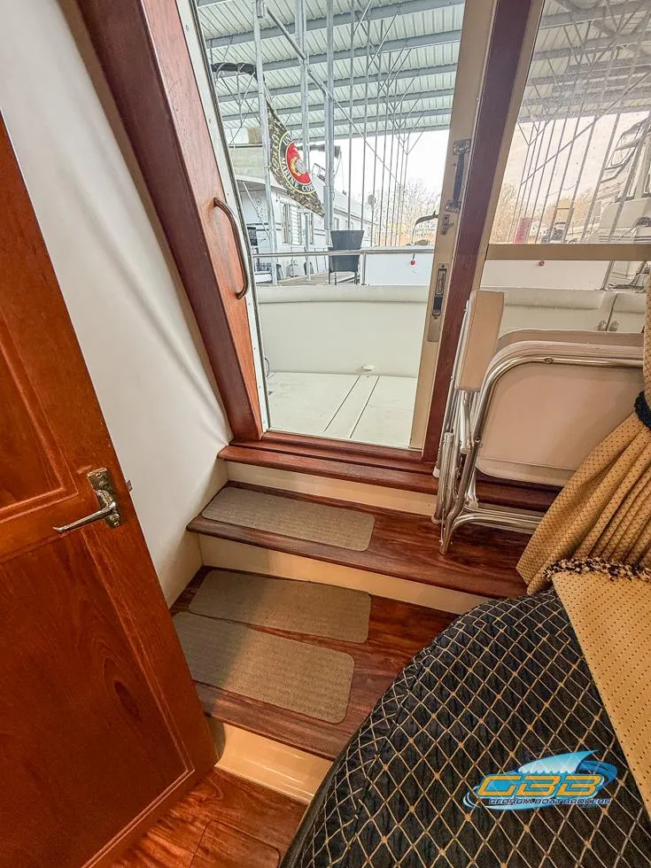 Slide: The Image of 1995 Carver 430 Cockpit Motor Yacht interior with wooden steps and sliding glass door. - 20