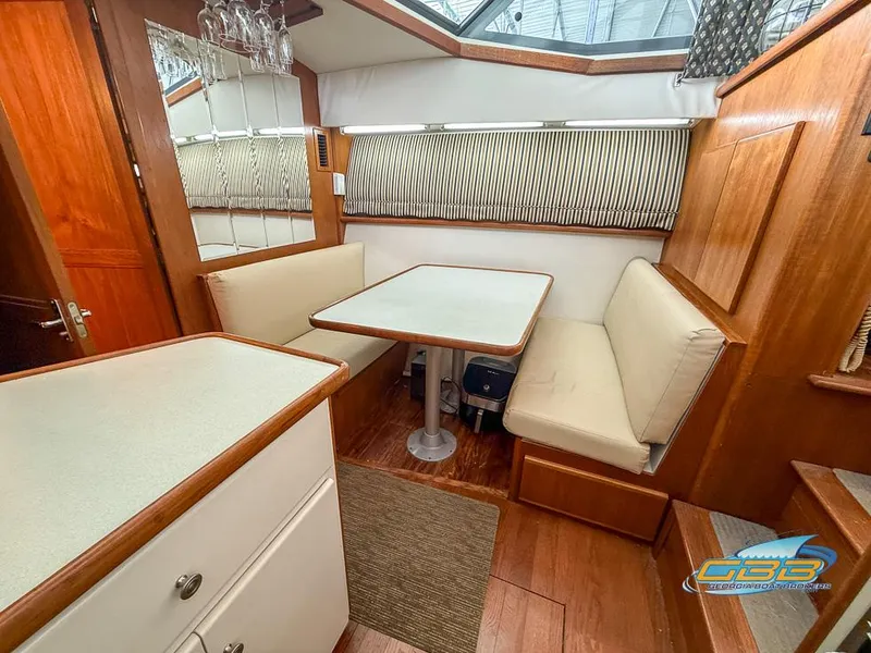 Slide: The Image of Interior of 1995 Carver 430 Cockpit Motor Yacht with dining area and wooden finishes. - 27