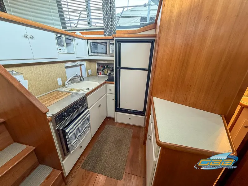 Slide: The Image of Interior of 1995 Carver 430 Cockpit Motor Yacht kitchen with appliances and wood finish. - 29