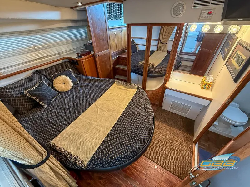 Slide: The Image of Luxurious 1995 Carver 430 Cockpit Motor Yacht bedroom with elegant decor and mirrored closet. - 3