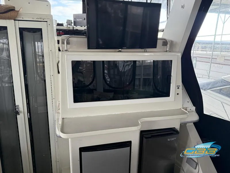 Slide: The Image of 1995 Carver 430 Cockpit Motor Yacht interior with TV and storage compartments. - 35