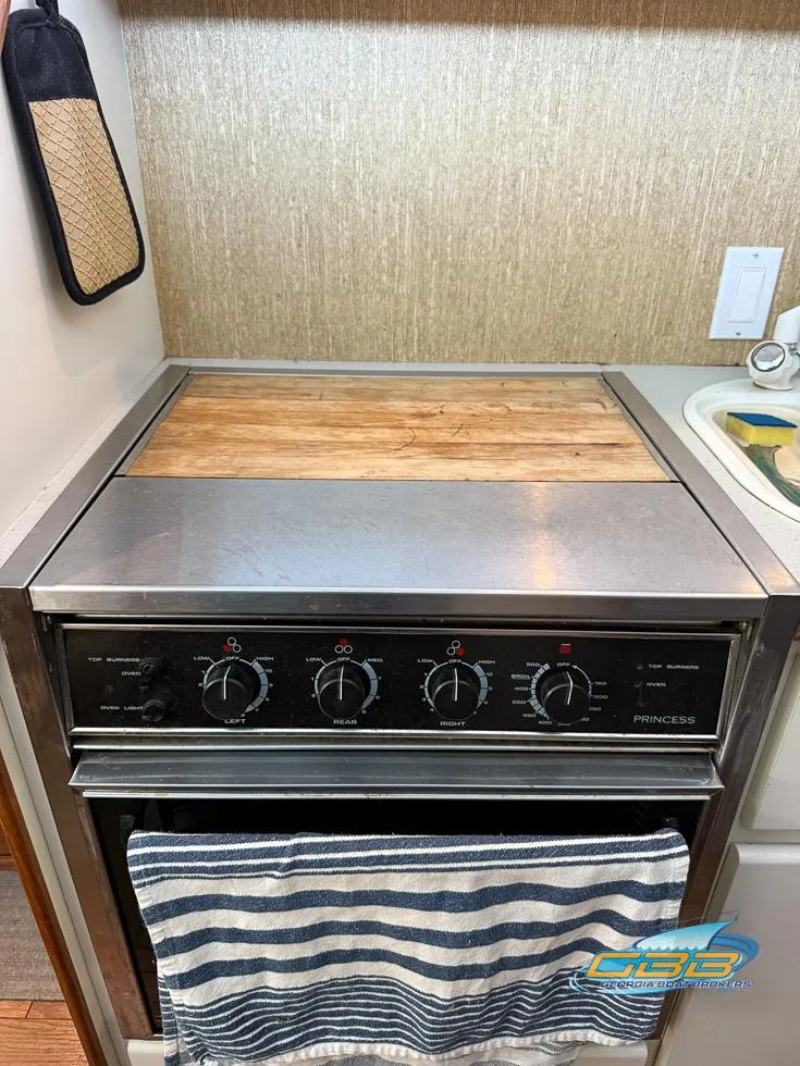 Slide: The Image of 1995 Carver 430 Cockpit Motor Yacht kitchen with stove and striped towel. - 41