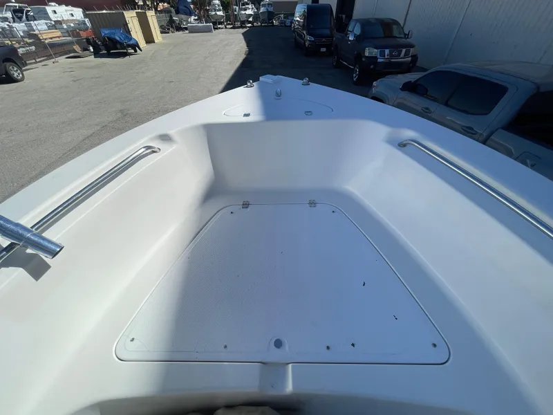 Slide: The Image of 2007 Tidewater 216 CC Adventure boat deck, parked in a lot with vehicles. - 14