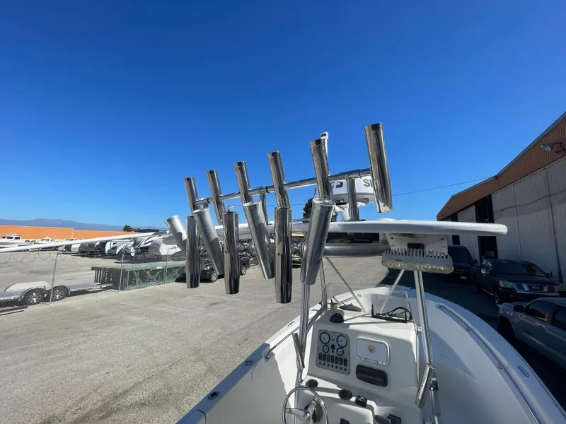 Slide: The Image of 2007 Tidewater 216 CC Adventure boat with rod holders, parked outdoors under clear blue sky. - 15
