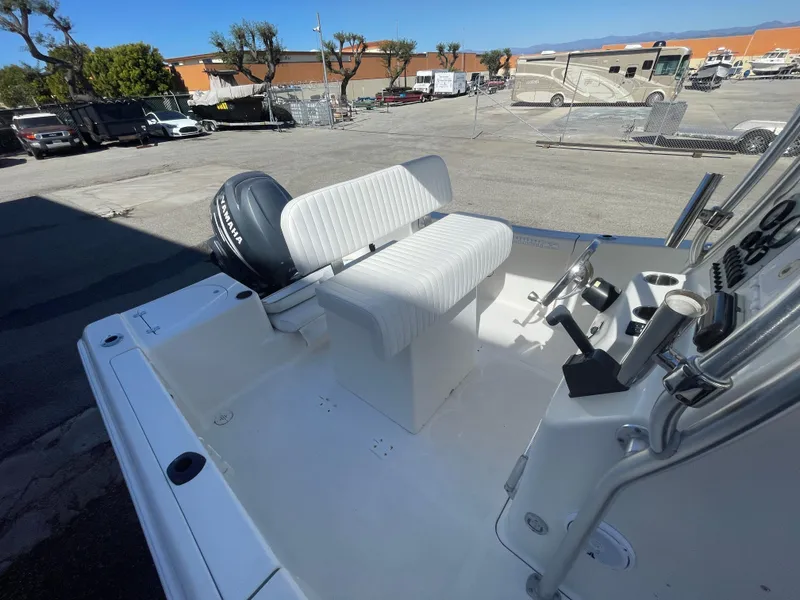 Slide: The Image of 2007 Tidewater 216 CC Adventure boat interior with seating and controls, parked outdoors. - 26