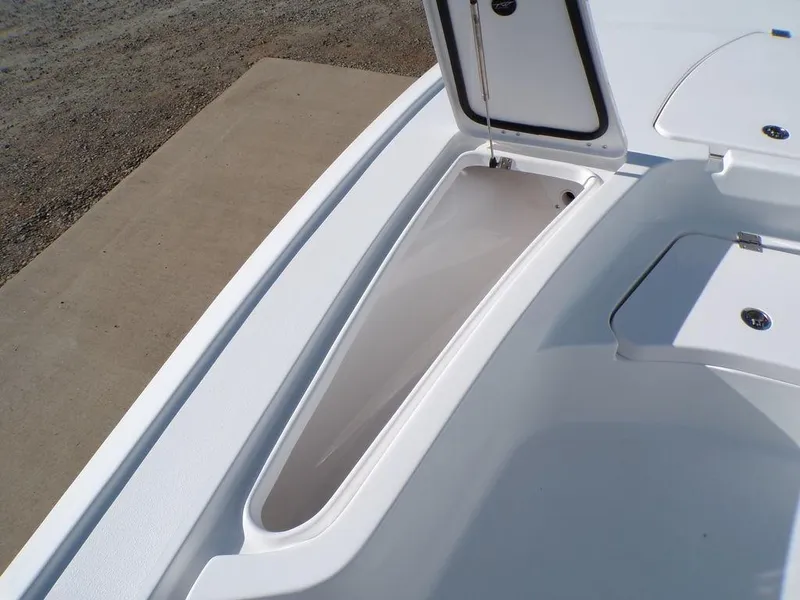 Slide: The Image of 2025 Tidewater 2410 BM boat storage compartment, open lid, white interior, on concrete surface. - 17