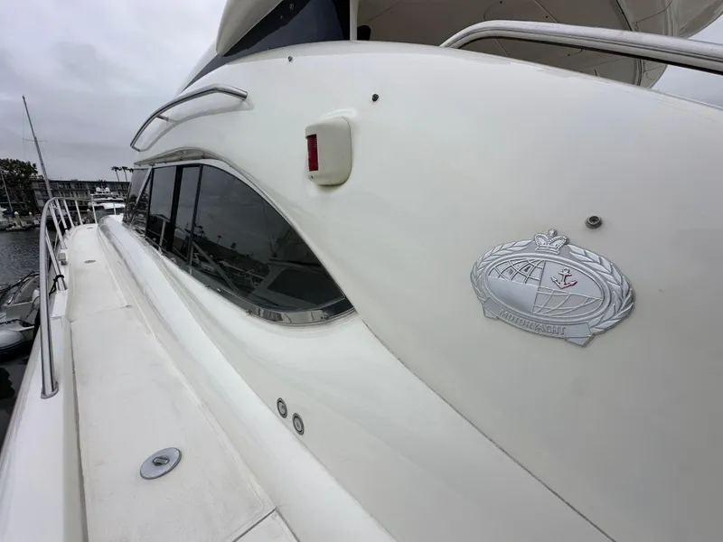Slide: The Image of Sunseeker Predator 60 yacht, 2000 model, sleek white exterior with emblem, docked at marina. - 15