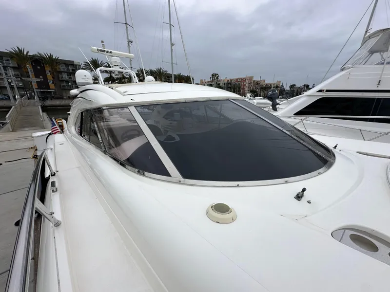 Slide: The Image of Sunseeker Predator 60 yacht, 2000 model, docked at marina under cloudy skies. - 24