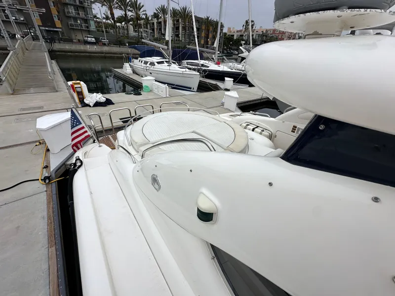 Slide: The Image of Sunseeker Predator 60 yacht docked at marina, showcasing sleek design and spacious deck. - 26