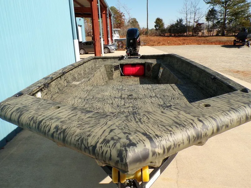 Slide: The Image of 2025 Tracker Grizzly® 1650 T Prairie Wings Edition boat with camouflage design, parked outdoors. - 2