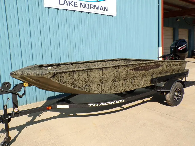 Slide: The Image of 2025 Tracker Grizzly® 1650 T Prairie Wings Edition boat on trailer, parked outside. - 3