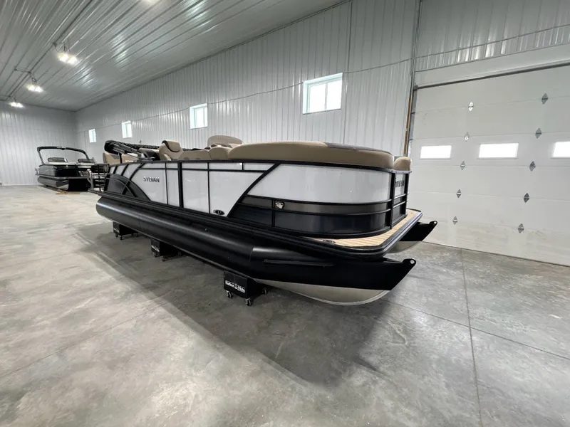Slide: The Image of 2024 Sylvan L3 RLZ pontoon boat in a spacious indoor showroom. - 4