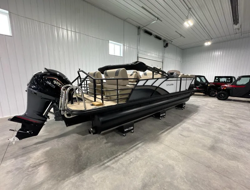 Slide: The Image of 2024 Sylvan L3 RLZ pontoon boat in a spacious indoor showroom. - 5
