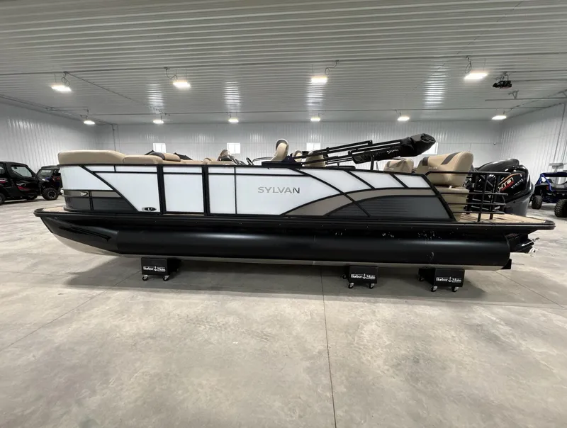 Slide: The Image of 2024 Sylvan L3 RLZ pontoon boat in a spacious indoor showroom. - 7
