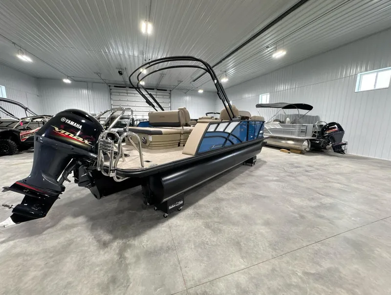 Slide: The Image of 2024 Sylvan Mirage X X3 CLZ DH pontoon boat in a spacious indoor showroom. - 11
