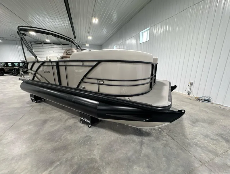 Slide: The Image of 2024 Sylvan Mirage 820 LZ pontoon boat with change room in a spacious indoor setting. - 4