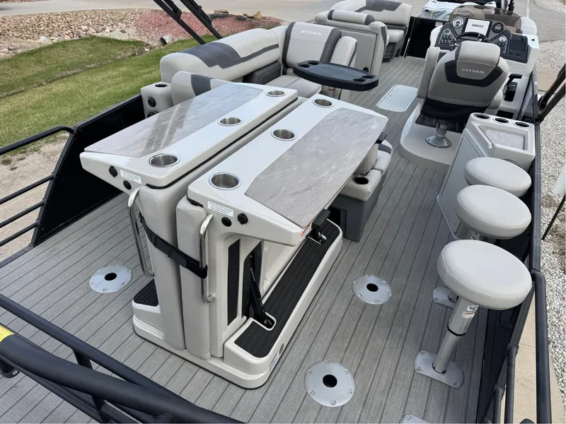 Slide: The Image of 2023 Sylvan L5 DLZ Bar pontoon boat interior with seating and bar stools. - 11