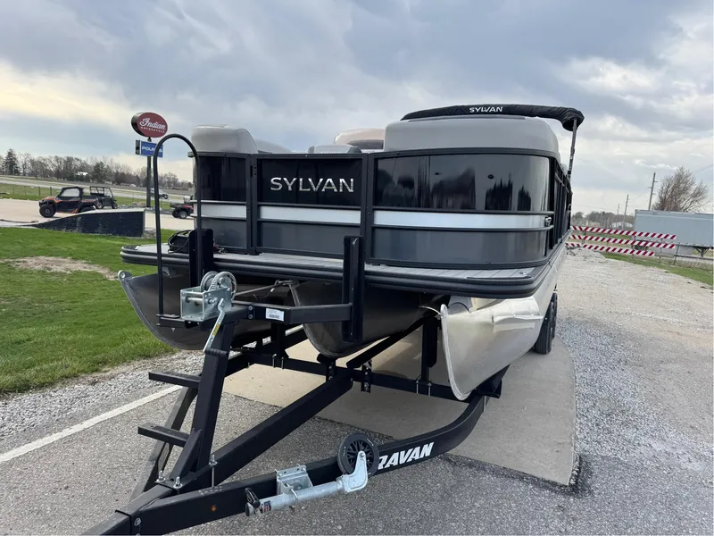 Slide: The Image of 2023 Sylvan L5 DLZ Bar pontoon boat on trailer, parked outdoors. - 17