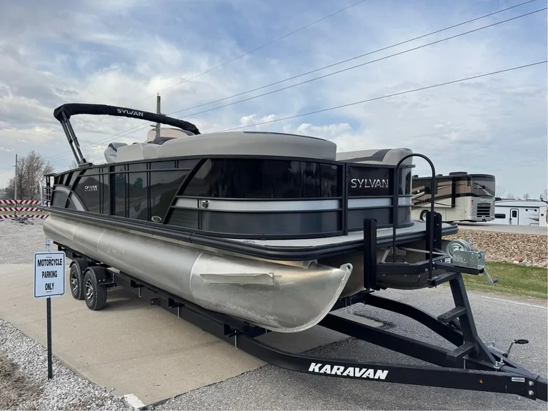 Slide: The Image of 2023 Sylvan L5 DLZ Bar pontoon boat on Karavan trailer, parked outdoors. - 18