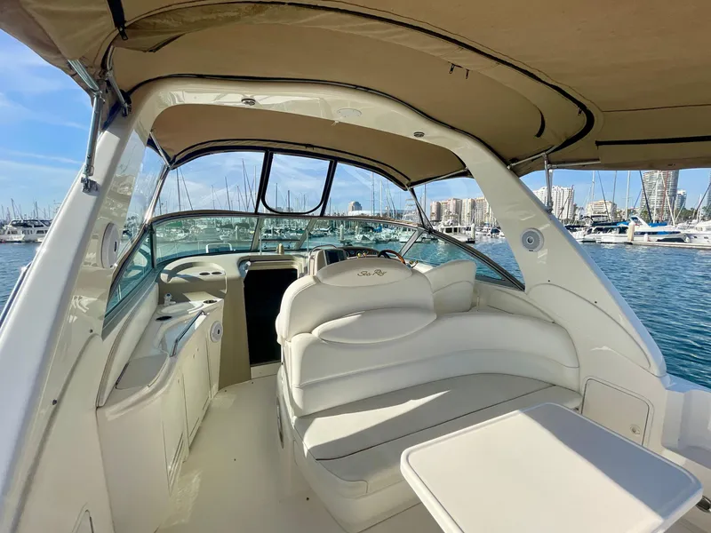 Slide: The Image of 2001 Sea Ray 340 Sundancer interior with white seating, marina view, and clear blue sky. - 10