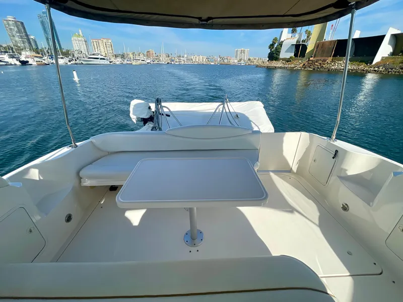 Slide: The Image of 2001 Sea Ray 340 Sundancer boat with spacious deck and seating area, docked in a marina. - 12