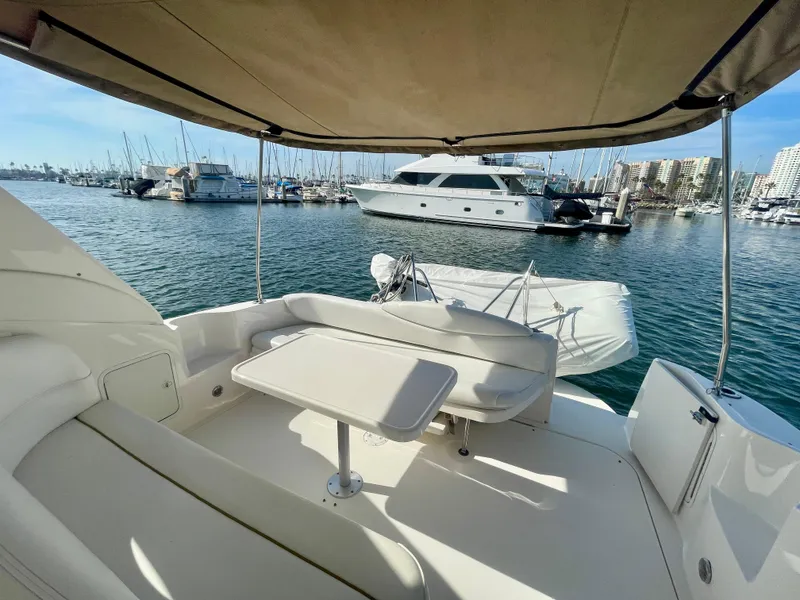 Slide: The Image of 2001 Sea Ray 340 Sundancer yacht interior with marina view, featuring seating and table. - 13