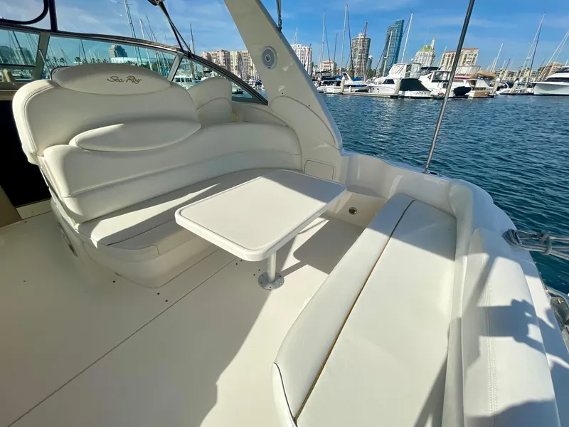Slide: The Image of 2001 Sea Ray 340 Sundancer yacht interior with white seating and table, marina view. - 15