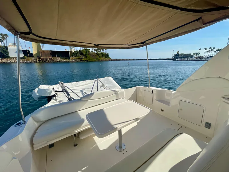 Slide: The Image of 2001 Sea Ray 340 Sundancer boat interior with seating and table, overlooking calm waters. - 16