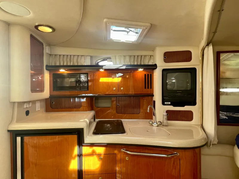 Slide: The Image of 2001 Sea Ray 340 Sundancer interior kitchen with wood cabinetry and modern appliances. - 18