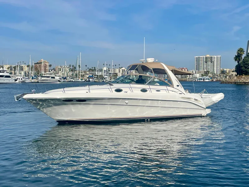 Slide: The Image of 2001 Sea Ray 340 Sundancer yacht on calm water, marina in background. - 2