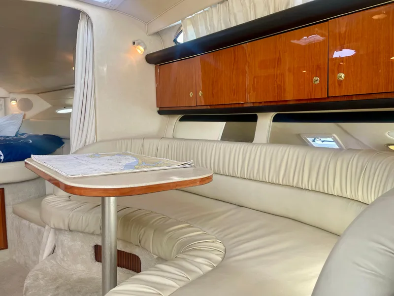 Slide: The Image of Interior of 2001 Sea Ray 340 Sundancer with plush seating and wooden cabinetry. - 23